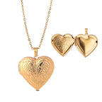 Gold heart-shaped locket with intricate designs on a white background